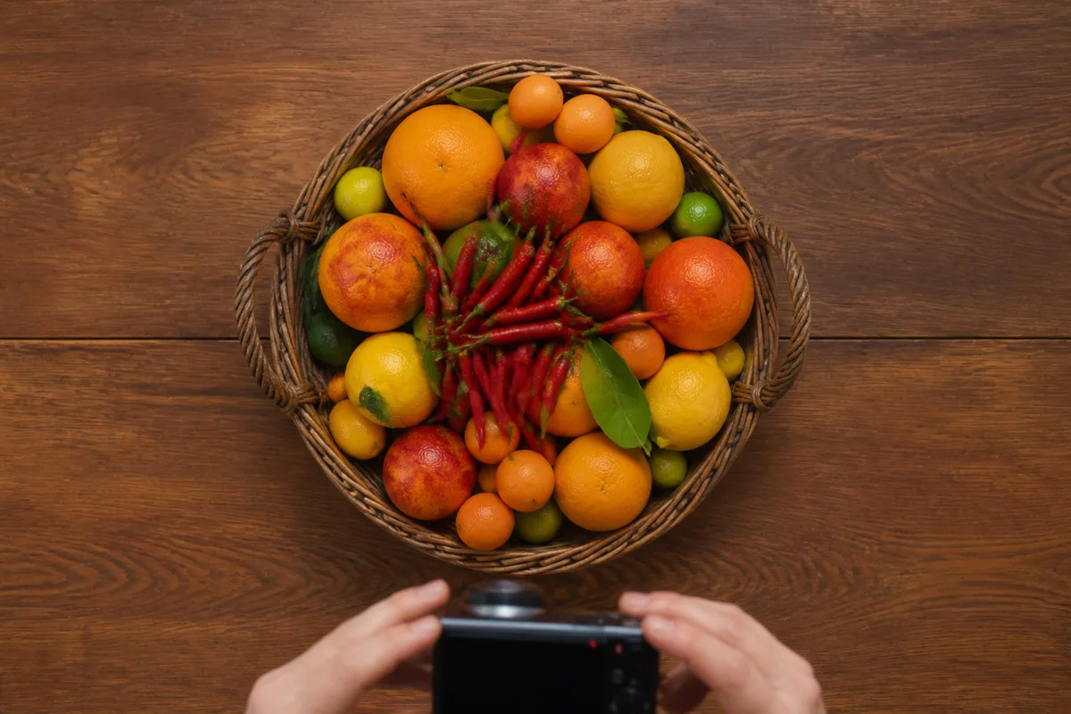 Panier d&rsquo;agrumes photographié en plongée verticale à 90° au-dessus d&rsquo;un plan de travail